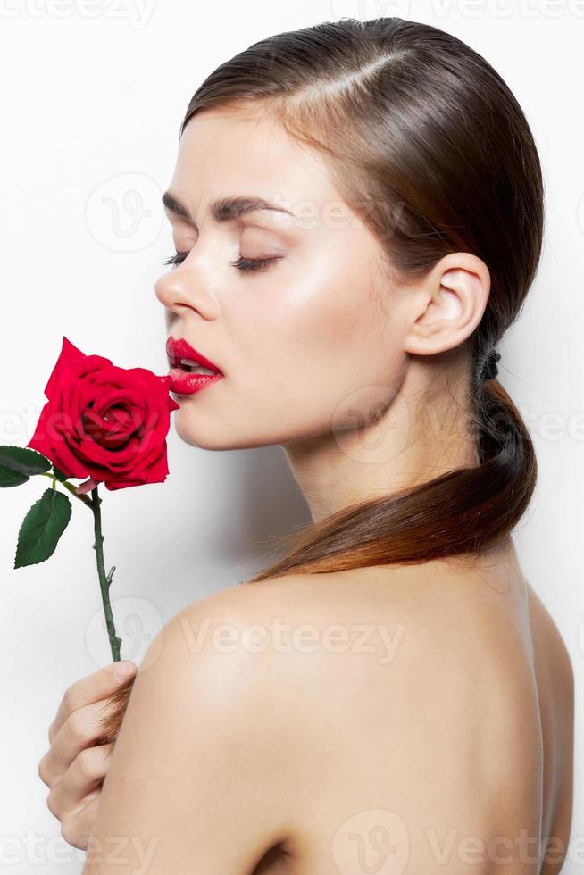 Dame mit Rose geschlossen Augen Blume in der Nähe von das Gesicht bilden foto