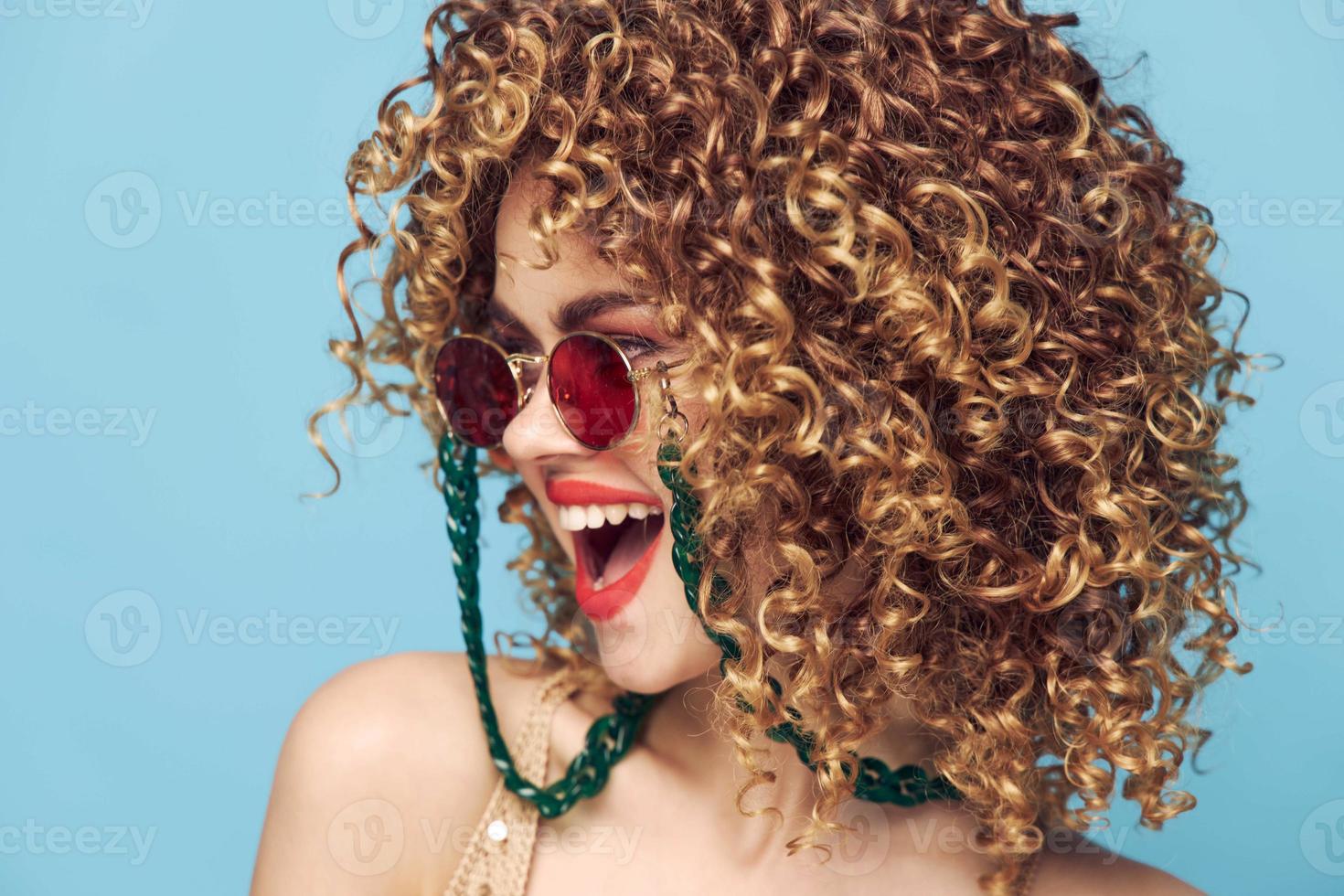 ziemlich Frau rot Lippen Spaß lockig Haar Nahansicht Sonnenbrille foto