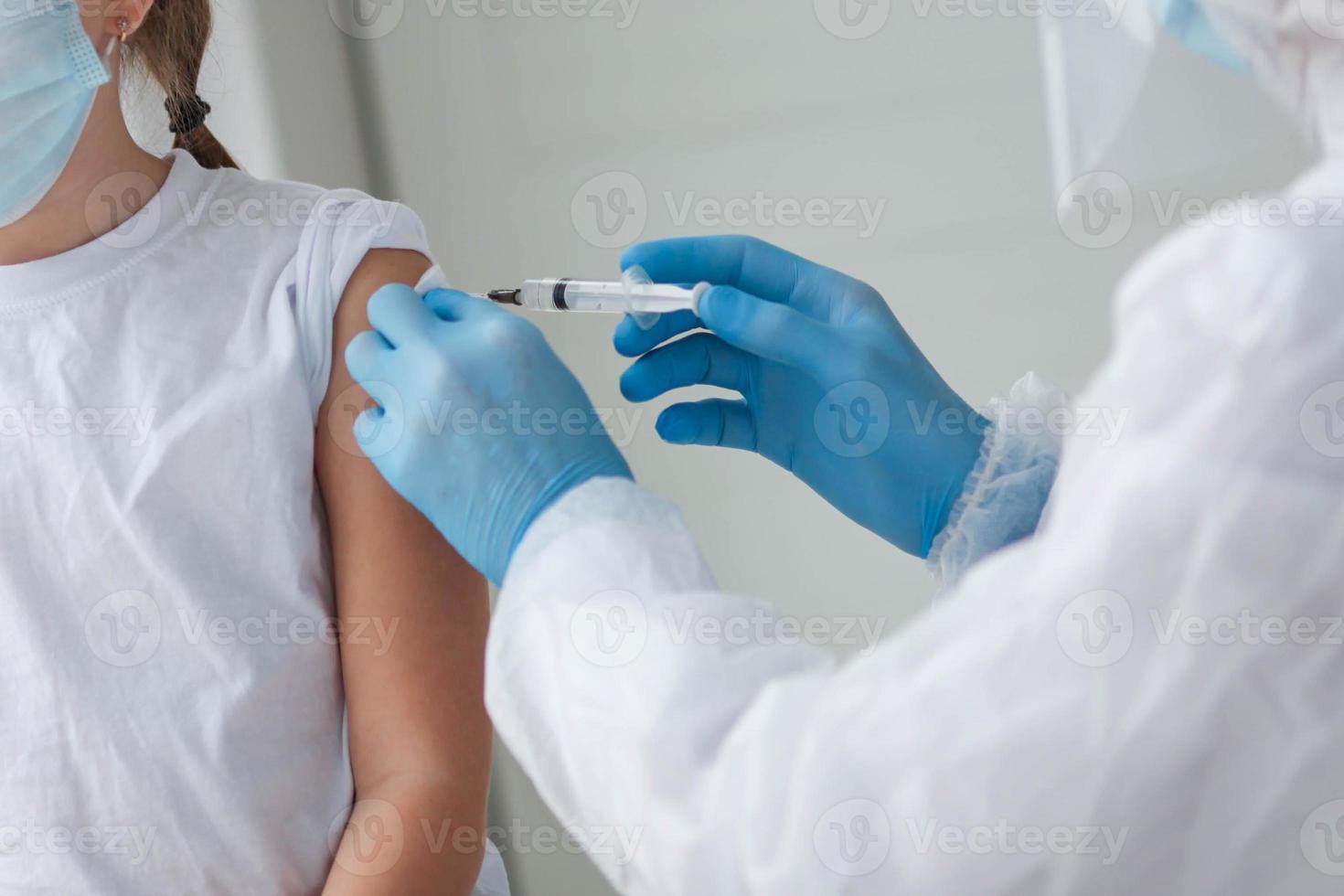 ein Arzt im ein schützend passen macht das Kind im ein medizinisch Maske ein Schulter Schuss . Coronavirus Impfung. covid-19 Impfung. Arzt Impfung Kind. Kinder beim Klinik. foto