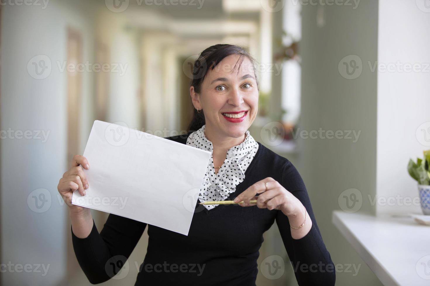 Frau im das Büro zeigt an auf ein Stück von Papier foto