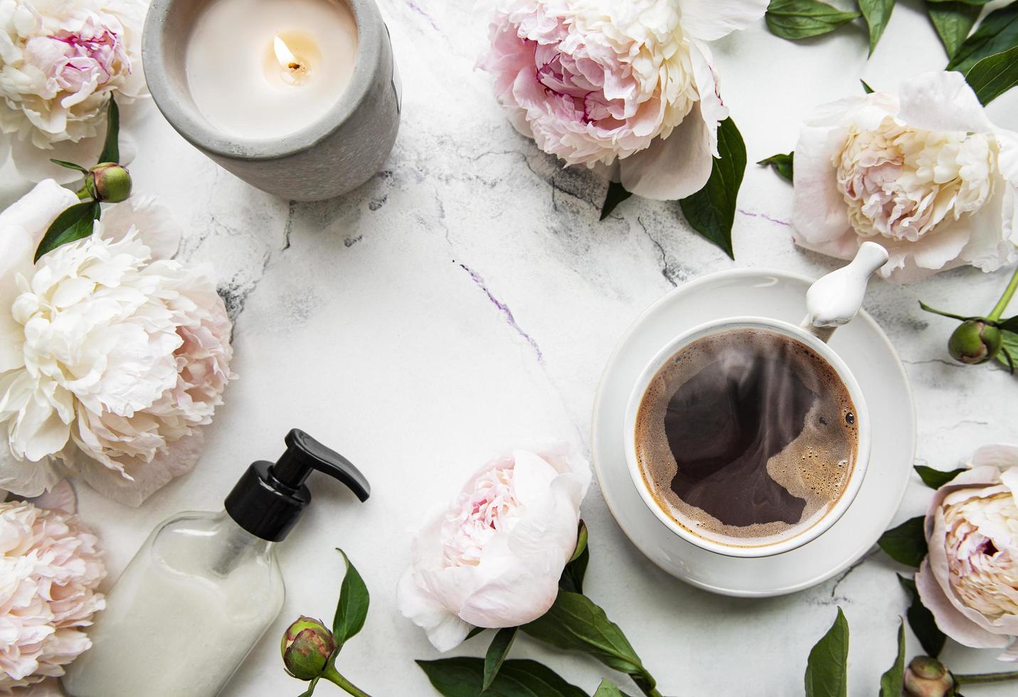 rosa Pfingstrosenblüten und eine Tasse Kaffee foto