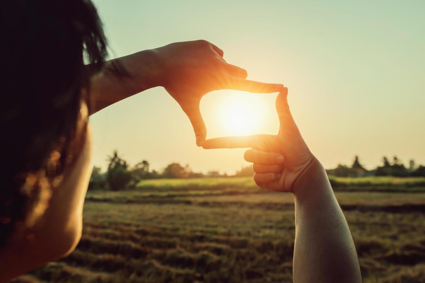 Frau Hand Rahmung Aussicht entfernt Über Sonnenuntergang. Geschäft Konzept foto