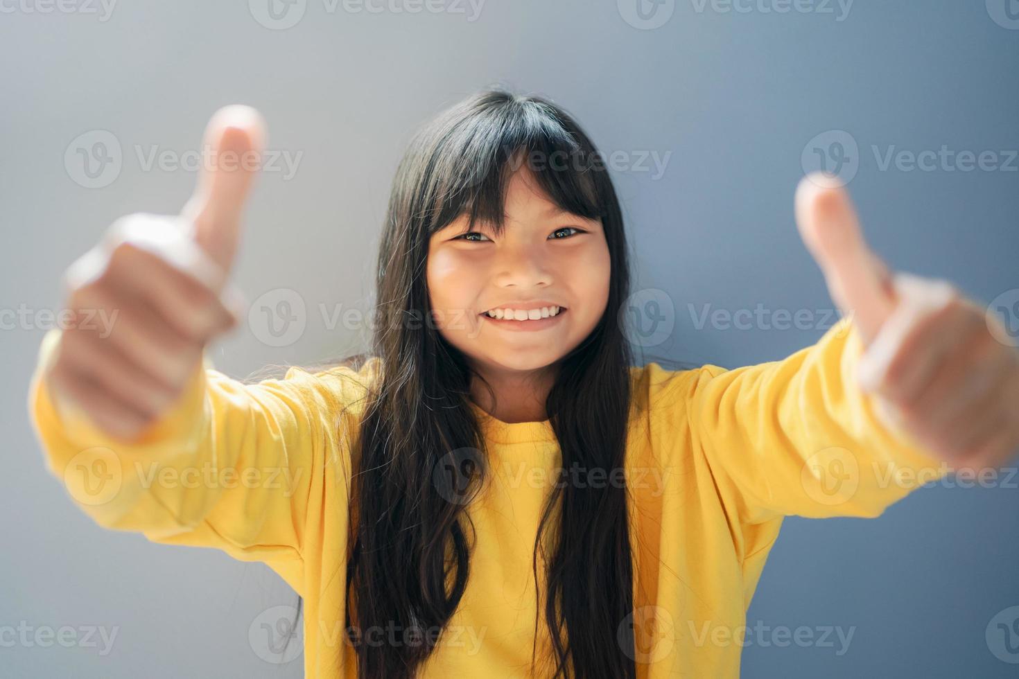 Kinder glücklich lächelnd mit Hand Daumen oben und Sonnenschein Hintergrund foto