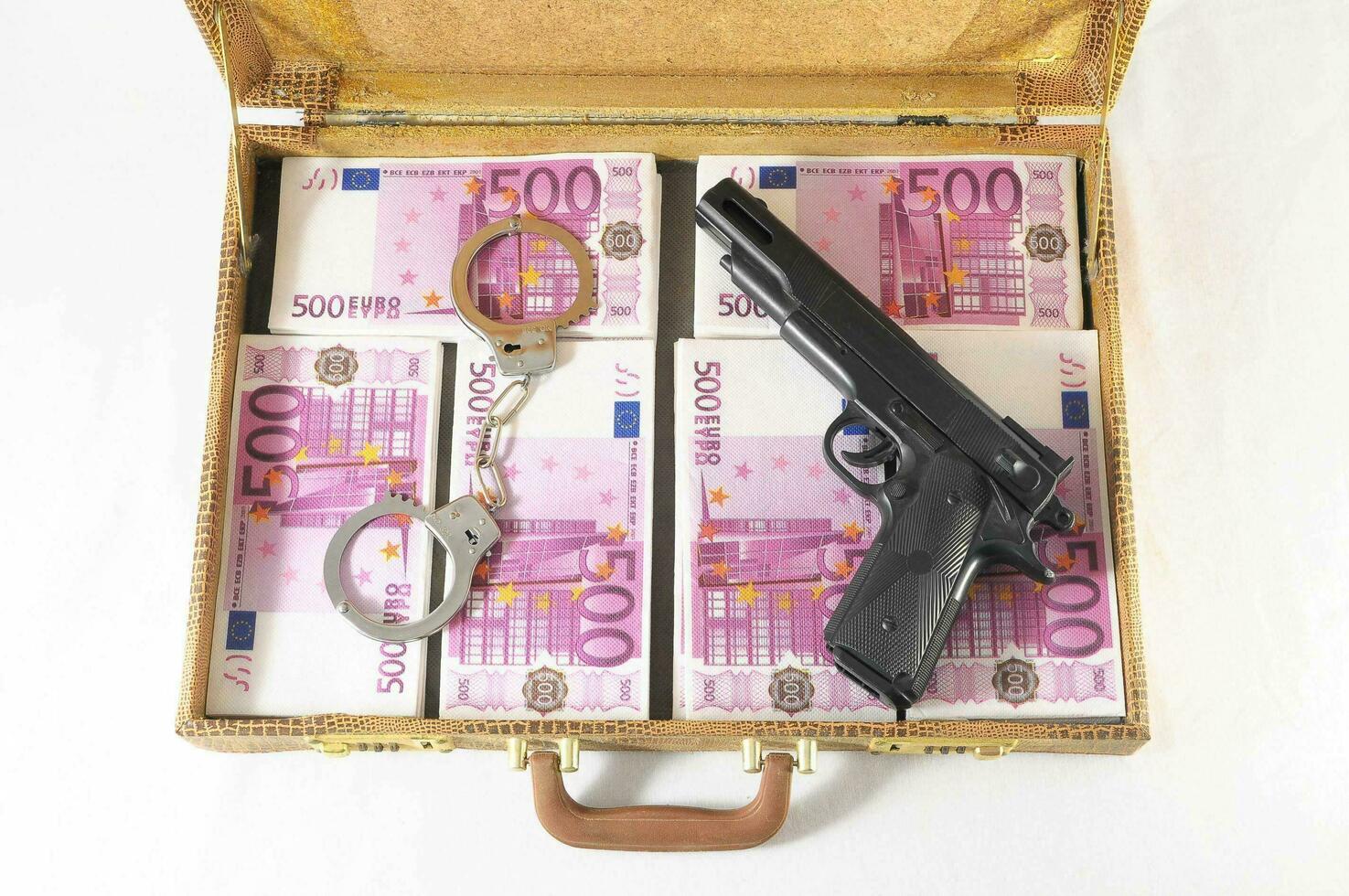 ein Aktentasche mit Geld, Gewehr und Handschellen foto
