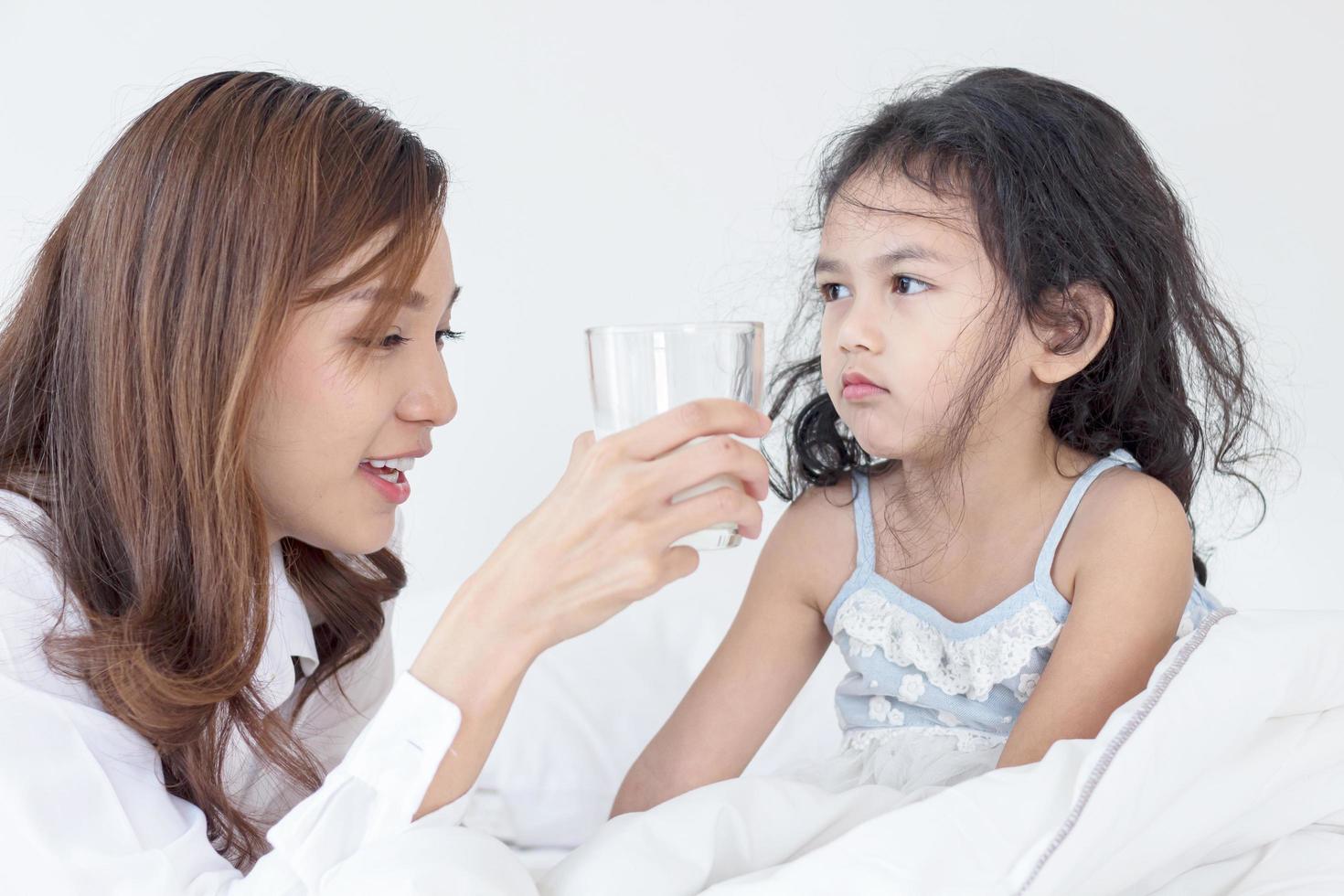 Mutter gibt ihrer Tochter morgens Milch foto