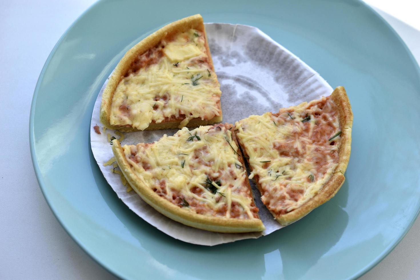 billige kleine Pizza mit Käse Nahaufnahme auf einem Teller foto