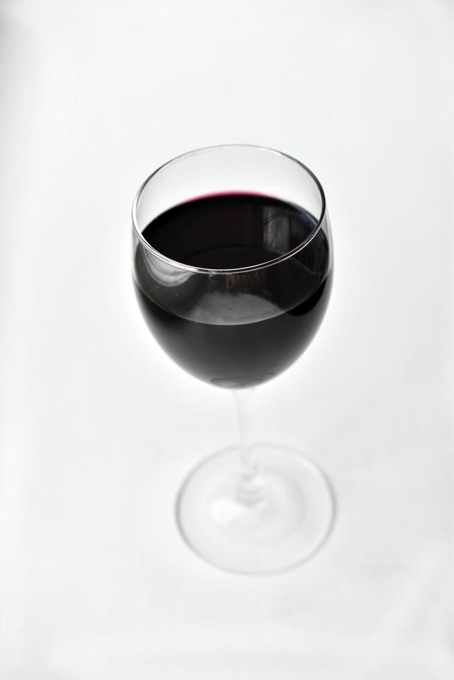 großes Glas Rotwein auf weißem Grund foto