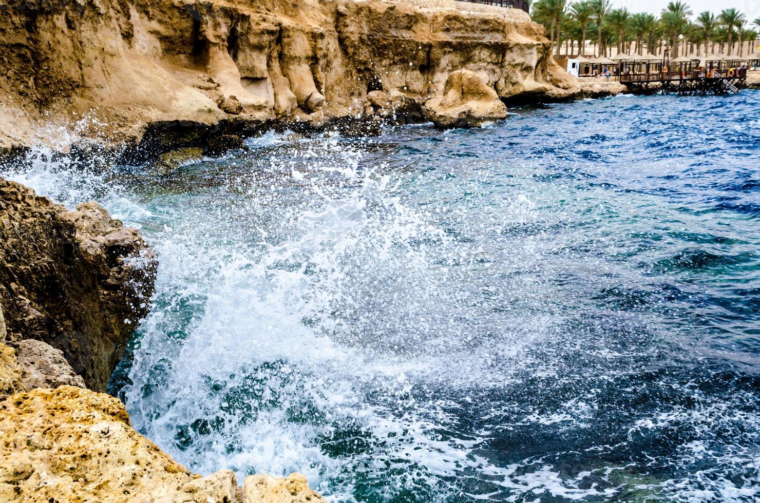 Ägypten, 2021 - plätschernde Wellen, die gegen die Felsen am Strand des Roten Meeres krachen foto