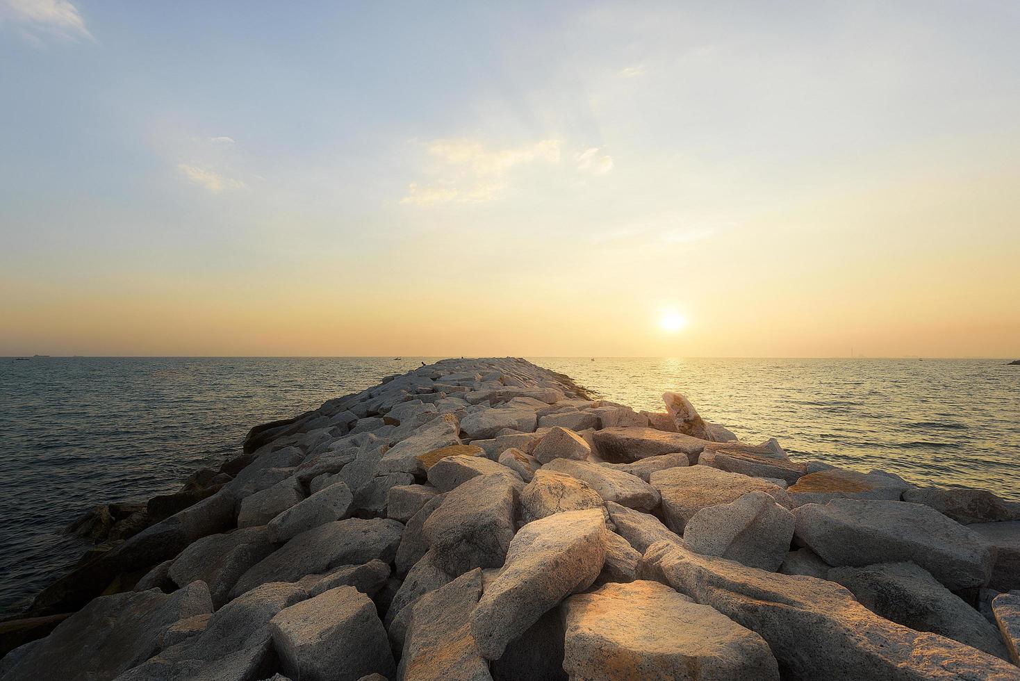 Sonnenuntergang am felsigen Ufer eines tropischen Strandes foto