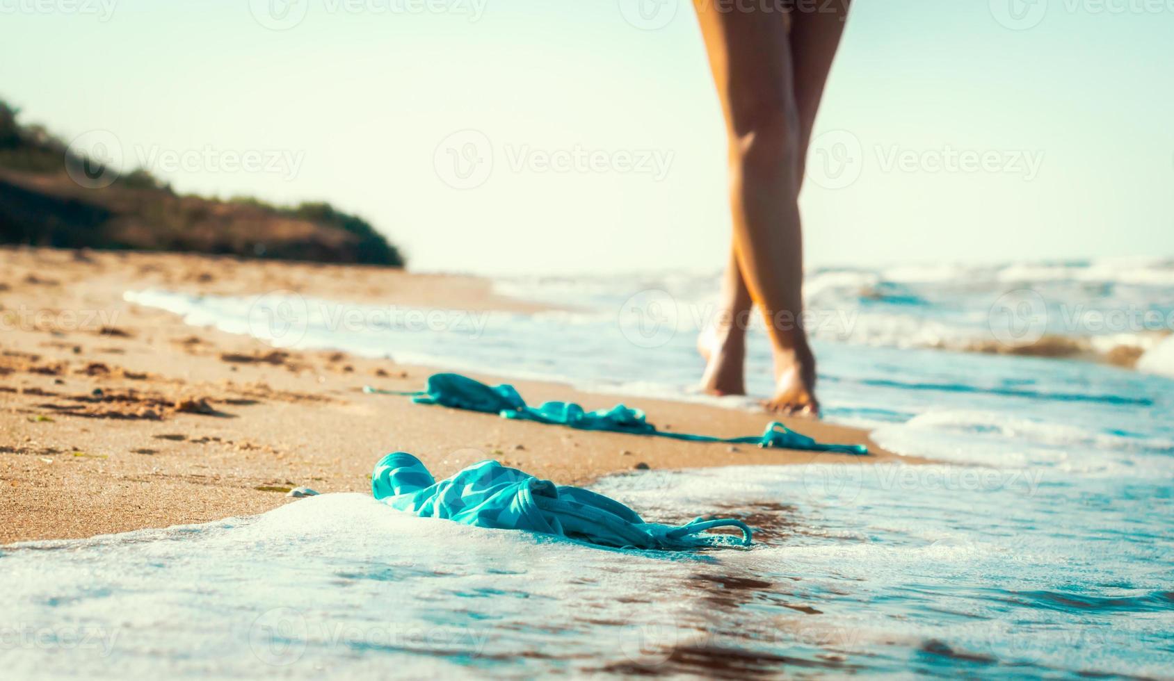 Badeanzug im Sand mit einer Frau am Strand spazieren foto