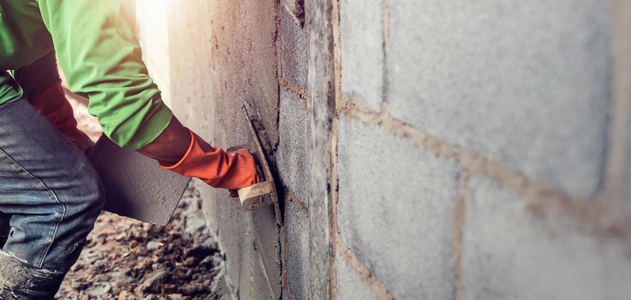 Arbeiter Verputzen Zement auf Mauer zum Gebäude Haus foto