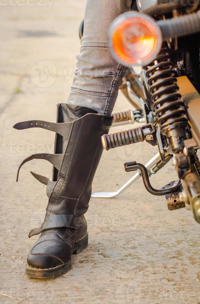 Stiefel eines Bikers mit einem Motorrad foto