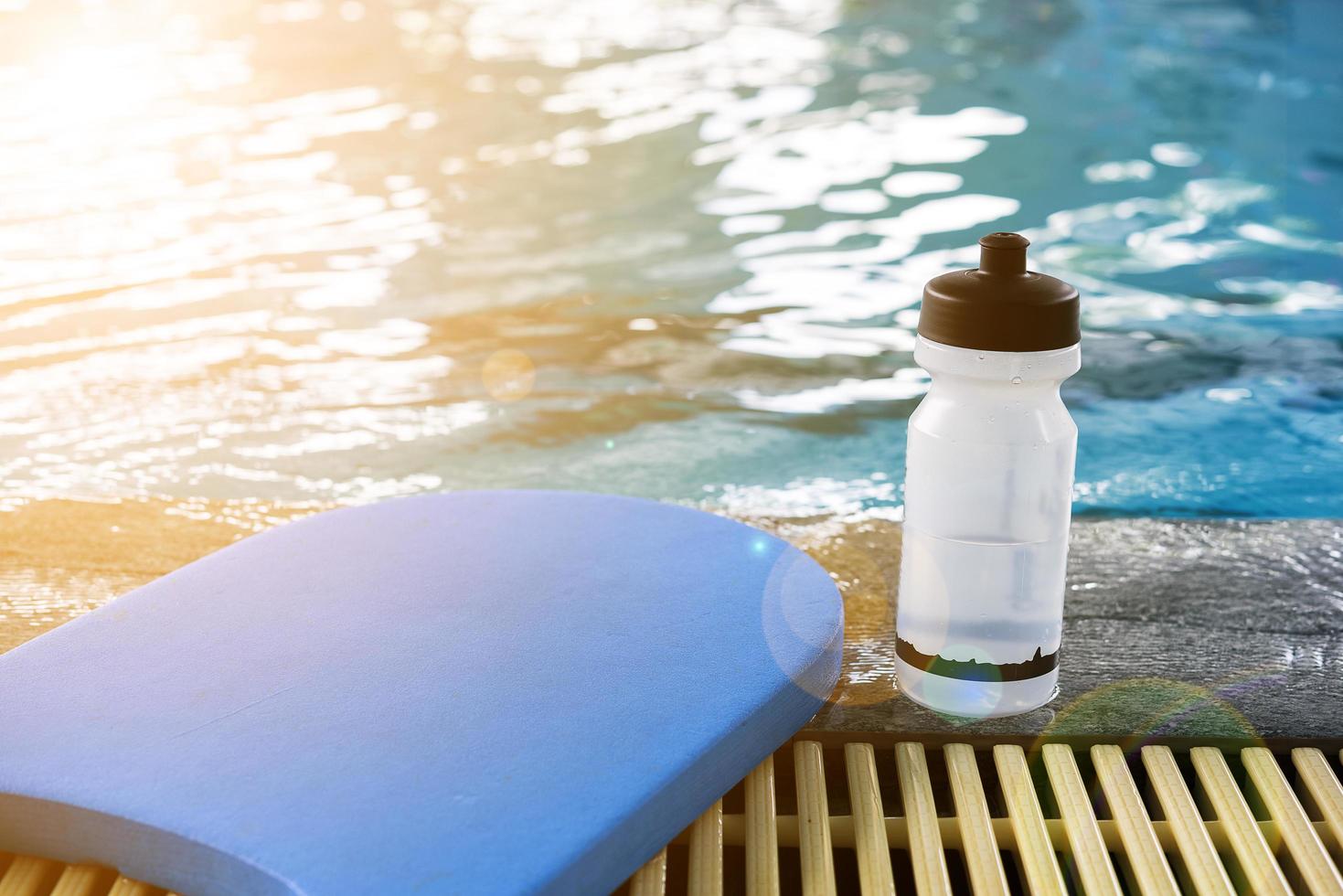 Kickboard und Wasserflasche auf einem Schwimmbad foto