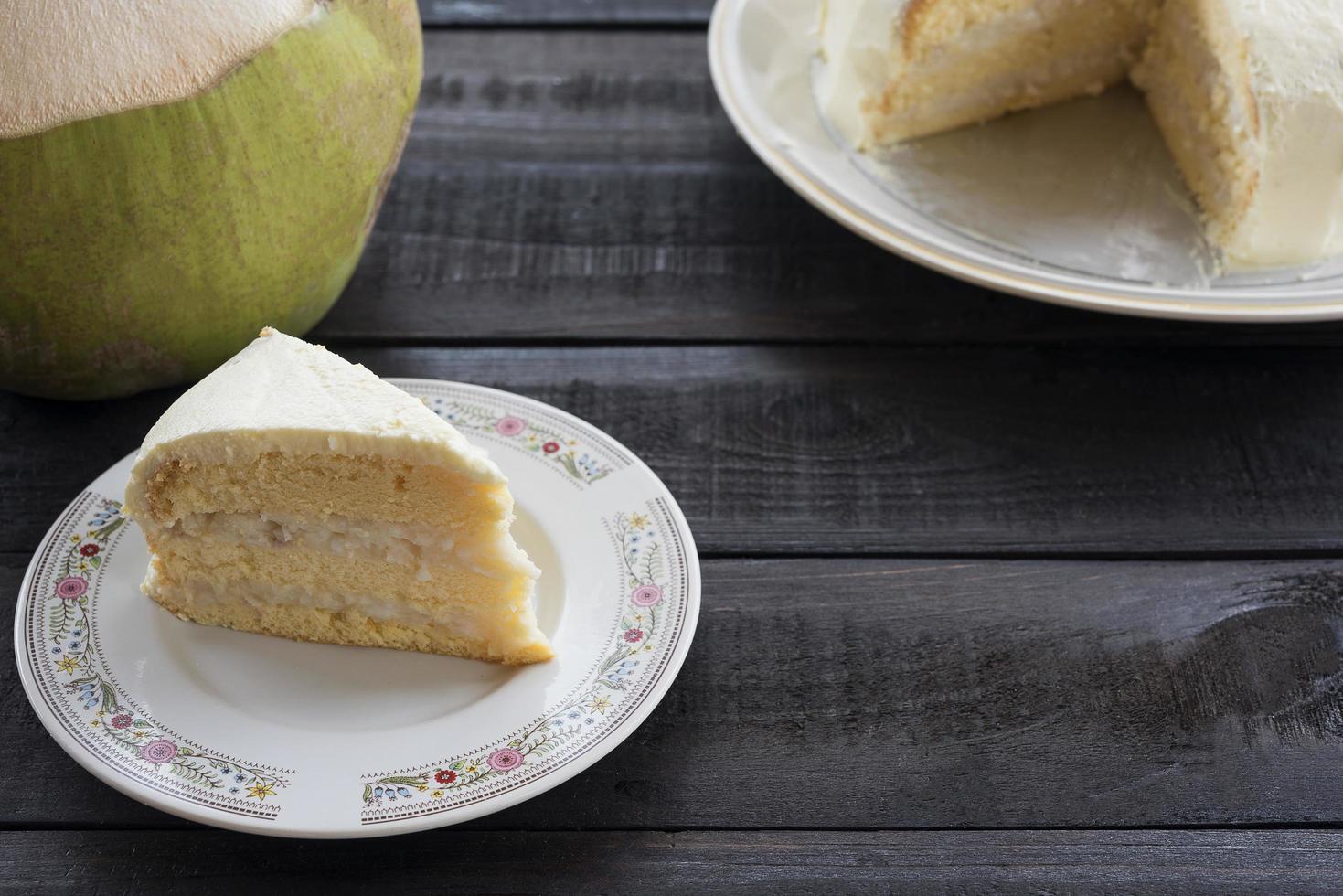 Kokoscremekuchen mit Kokosnussfrucht auf einem hölzernen Hintergrund foto