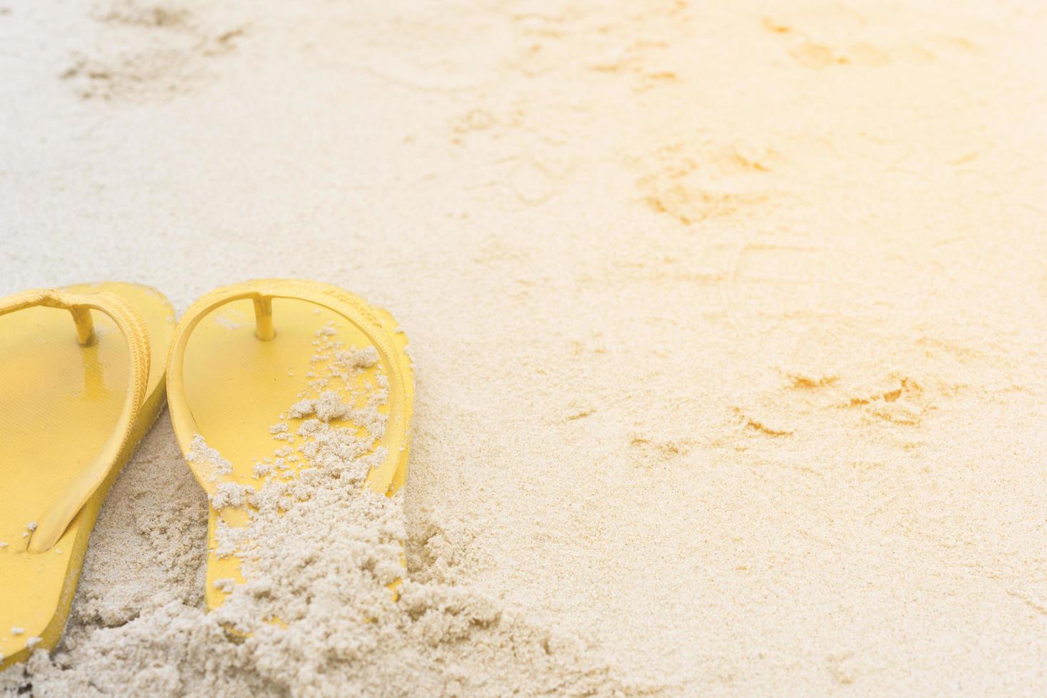 gelbe Sandalen am Strand im Sommer foto