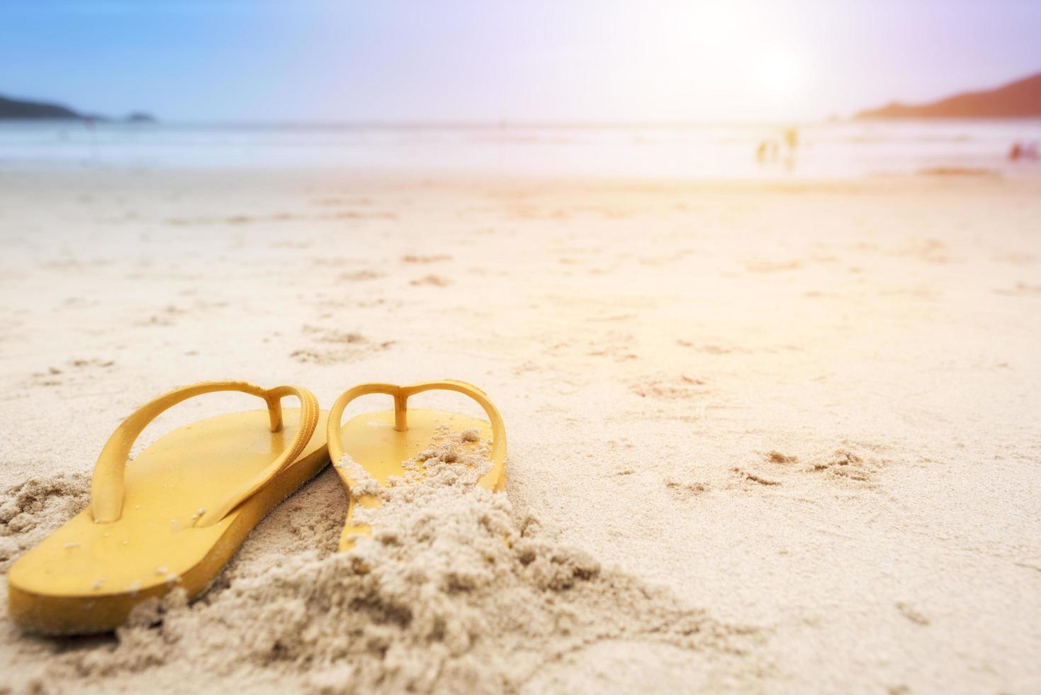 gelbe Sandalen am Strand im Sommer foto