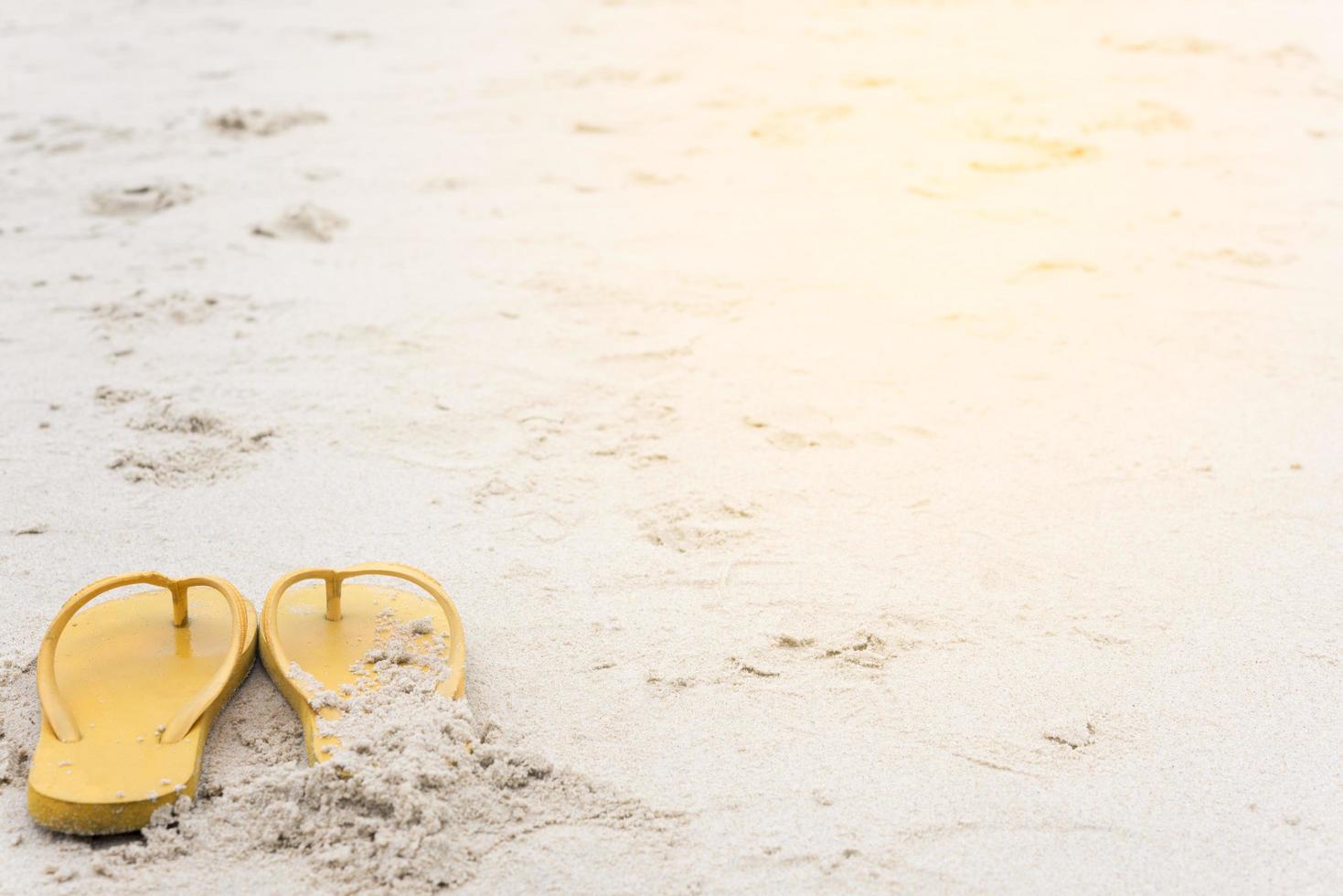 gelbe Sandalen am Strand im Sommer foto