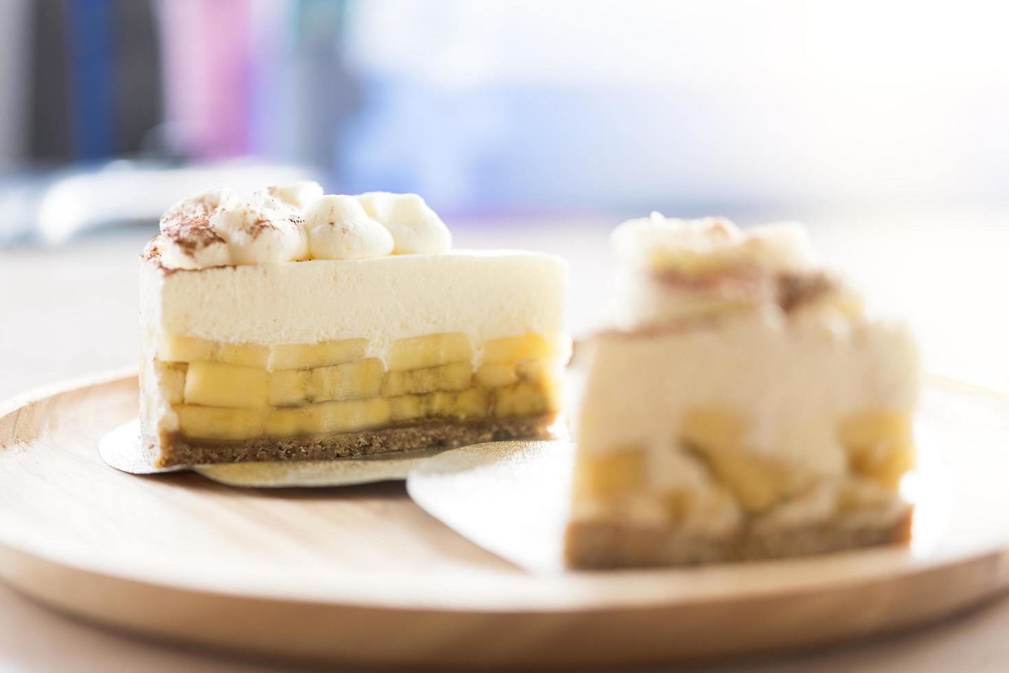 zwei Banoffee Pies mit Schokoladenpulver auf einem Holzteller foto