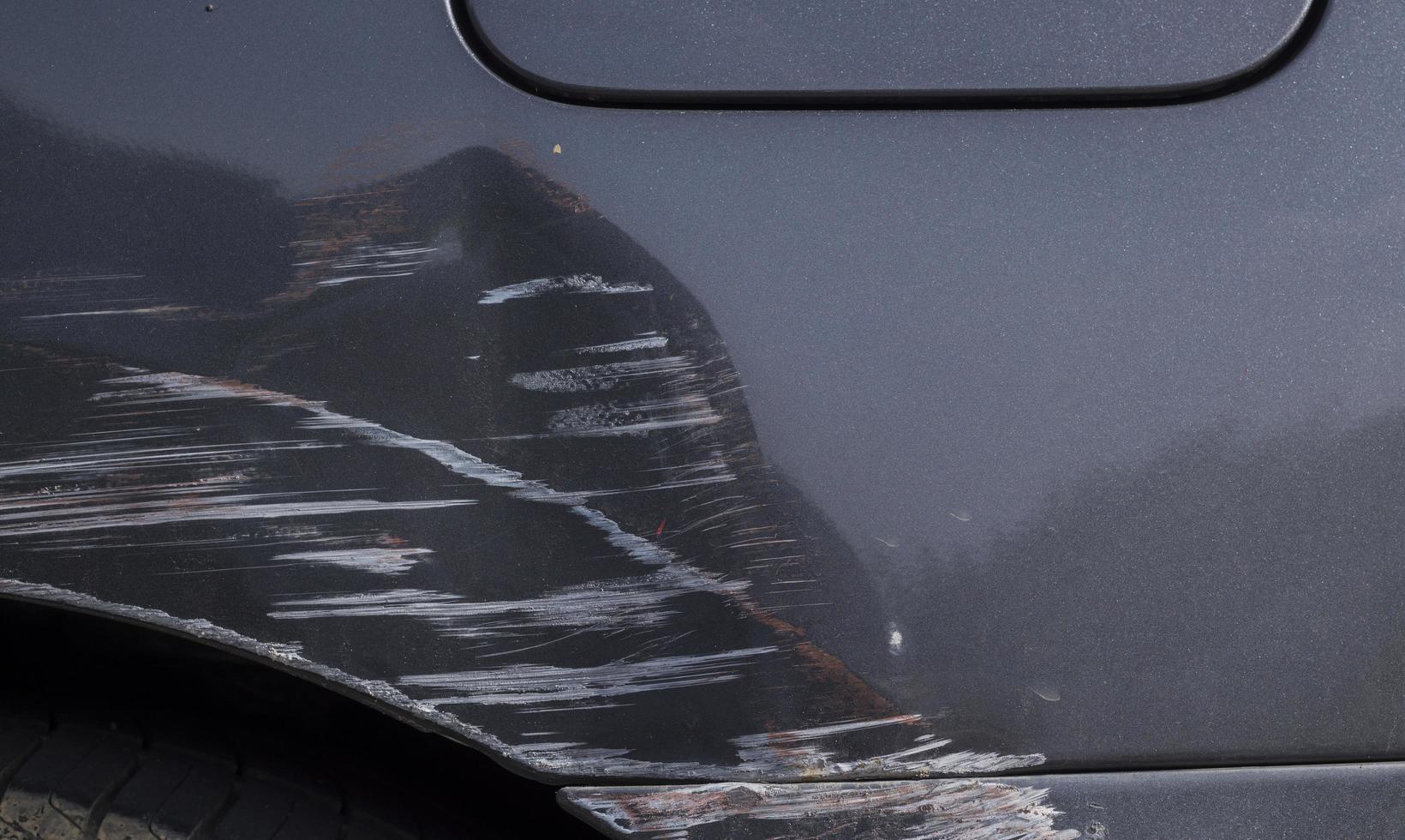 Kratzer auf der Karosserie eines grauen Autos durch einen Autounfall foto