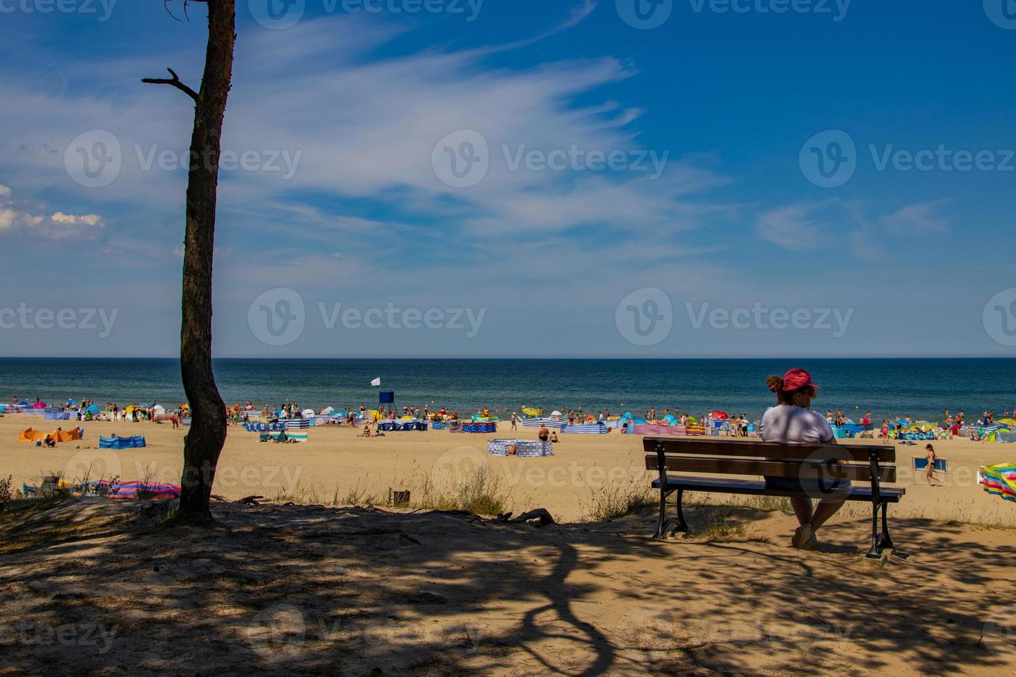 Aussicht von das Böschung zu das Strand auf das baltisch Meer auf ein Sommer- Tag mit Menschen foto