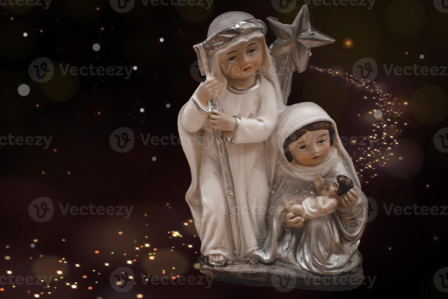 Keramik Figuren von das Mutter von Gott Joseph und Baby Jesus zum das Geburt Szene auf ein dunkel braun Hintergrund foto