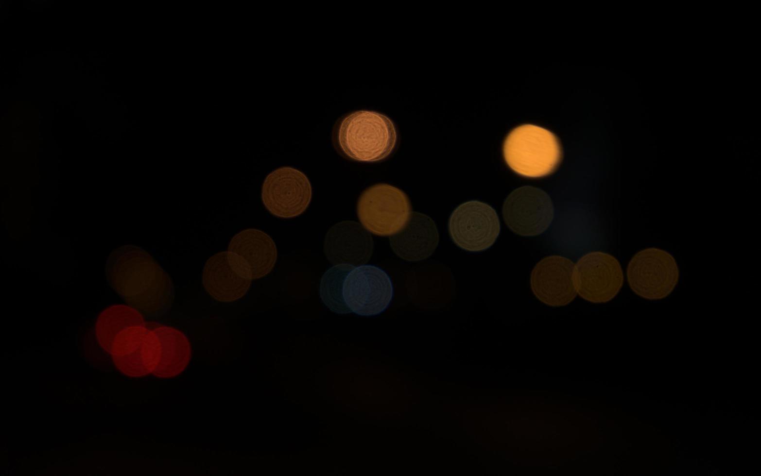 verschwommenes Bokeh von Autolichtern in der dunklen Nacht in der Stadt foto