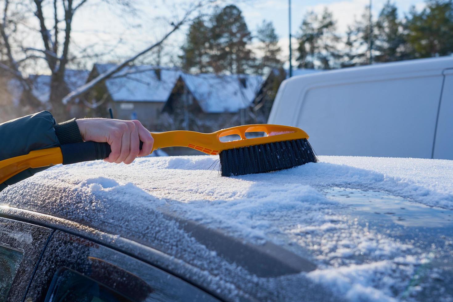 Schnee vom Dach eines Autos entfernen foto