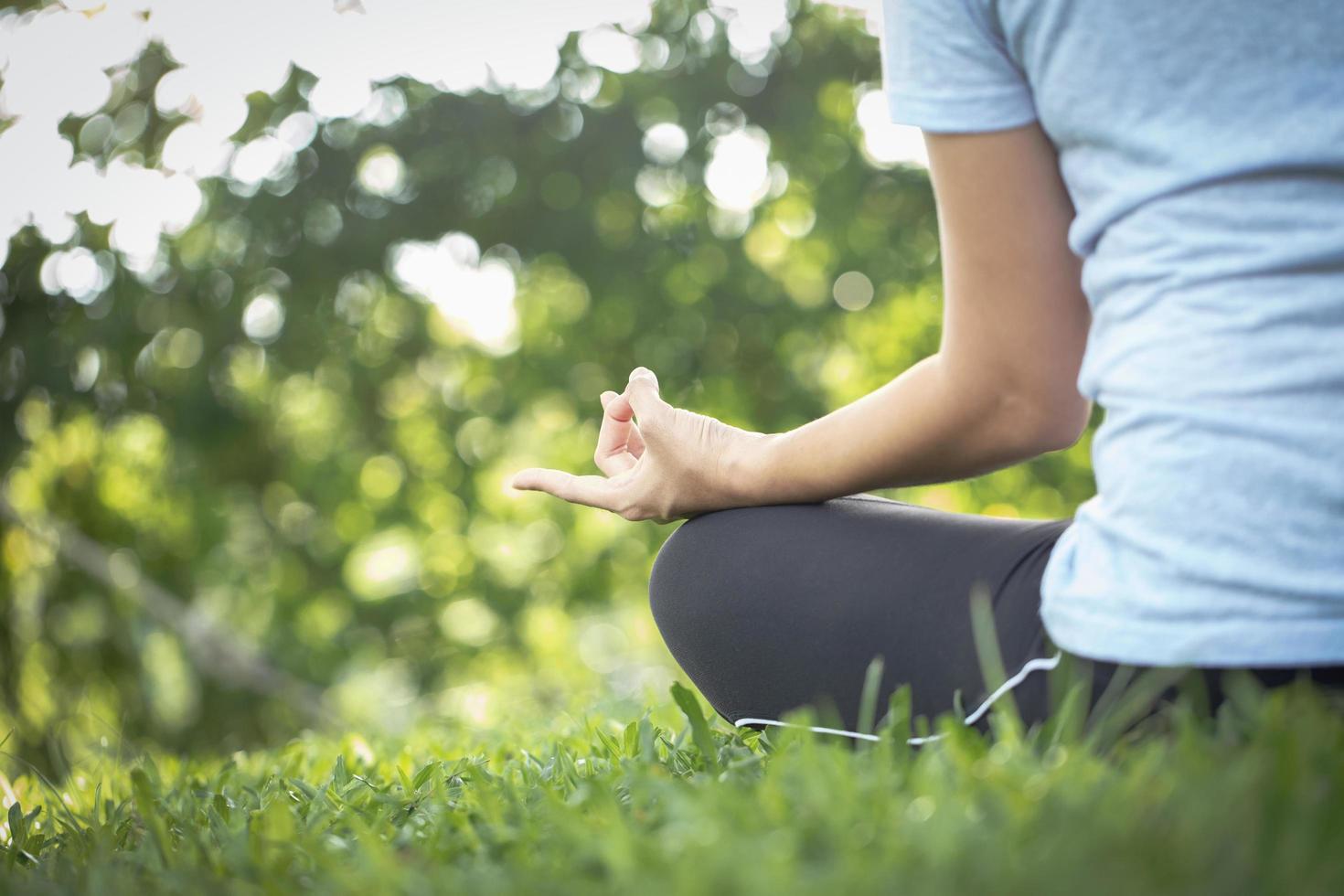 Nahaufnahme einer Frau, die in einem Park meditiert foto
