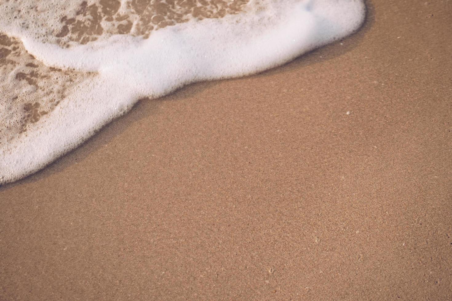 Draufsicht auf Sand und Meerwasserspritzer mit Kopierraum an einem tropischen sauberen Sommerstrand foto