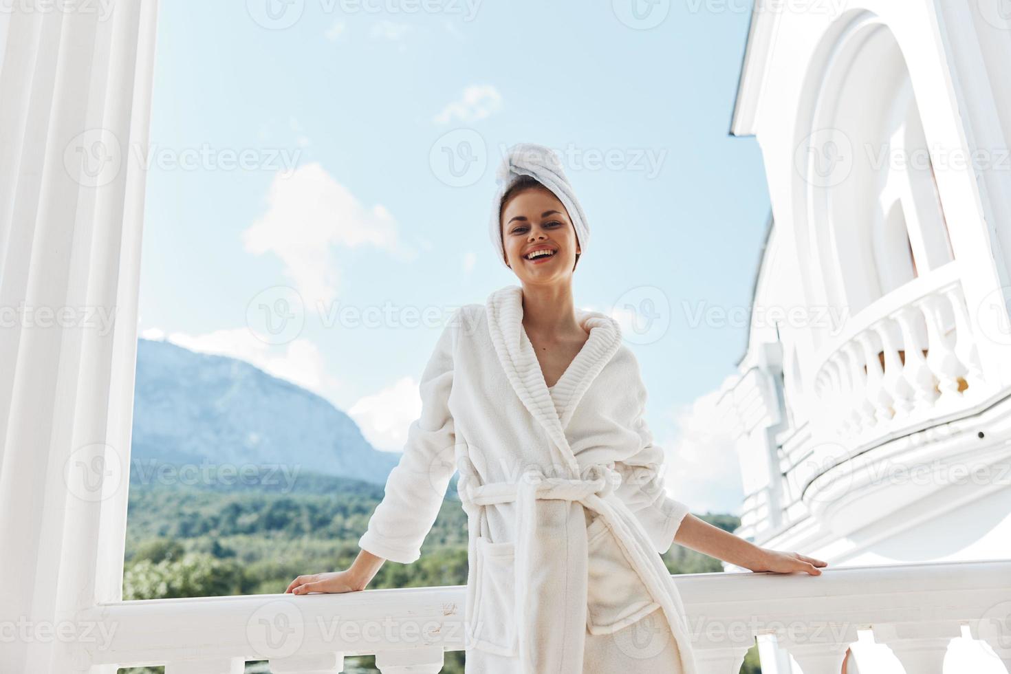 ziemlich Frau im ein Weiß Kleid auf das Balkon bisschen auf Grün Natur unverändert foto