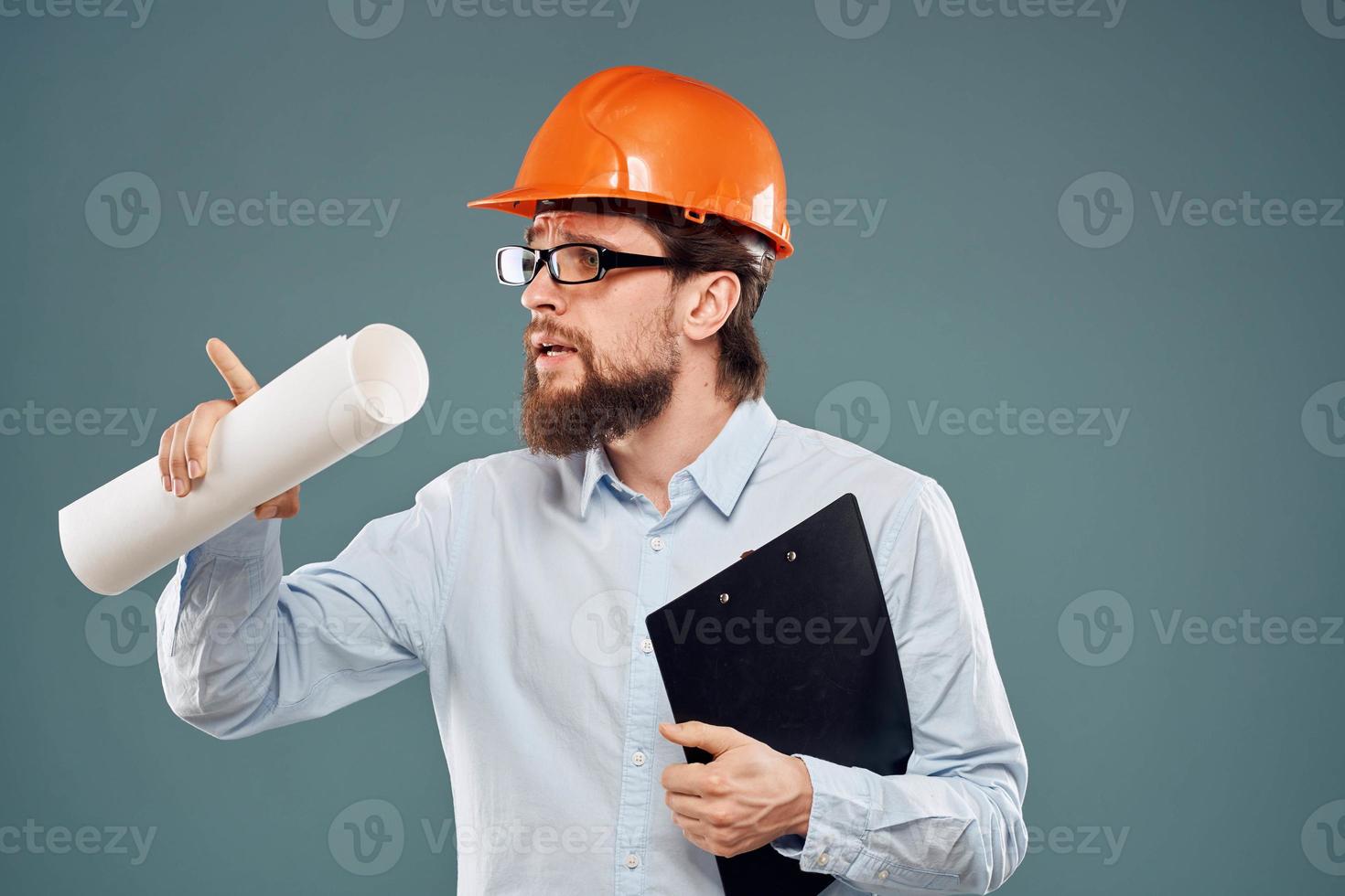 männlich Ingenieur Fachmann Orange schwer Hut Sicherheit Konstruktion Blaupausen im Hände foto