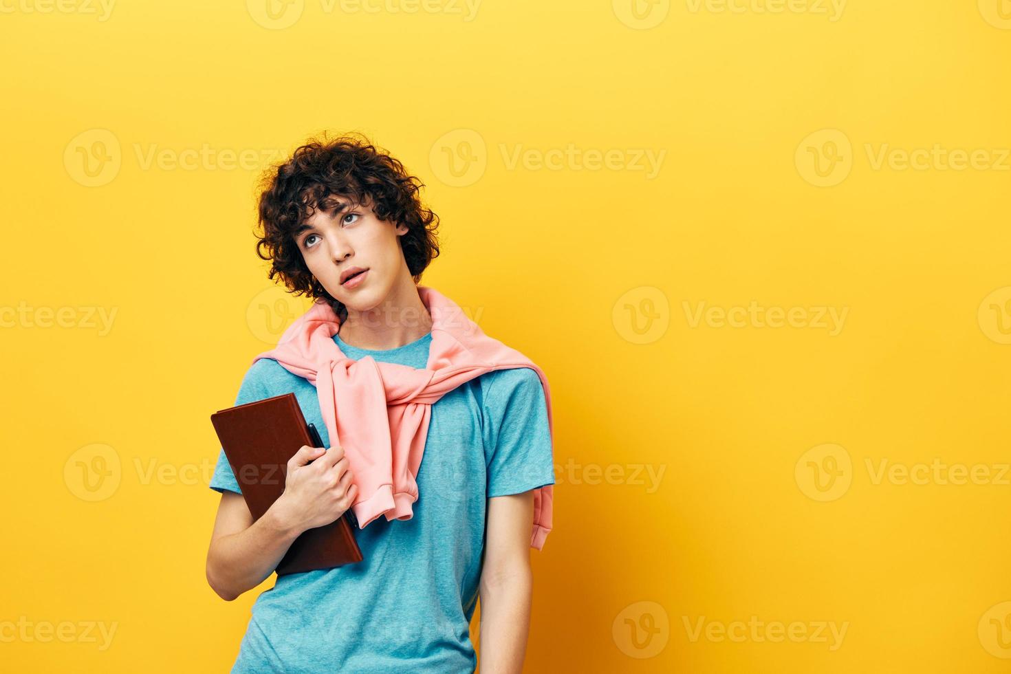 Kerl mit ein Buch Hochschule Lernen Rosa Jacke Gelb Hintergrund foto