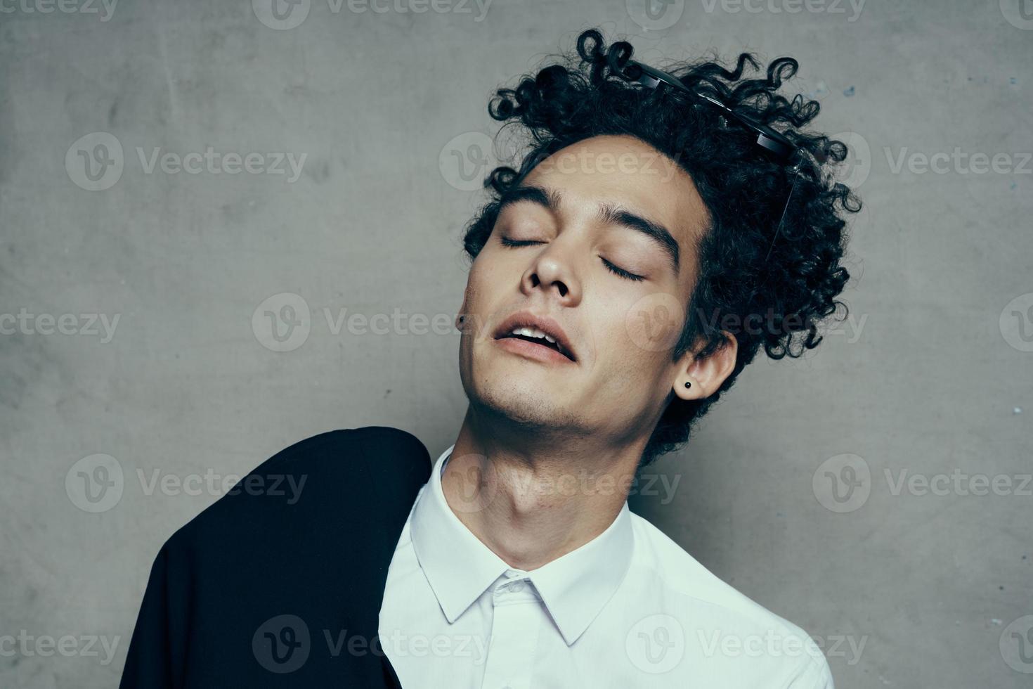 emotional Kerl mit lockig Haar Teen klassisch passen Sonnenbrille Hemd Modell- foto