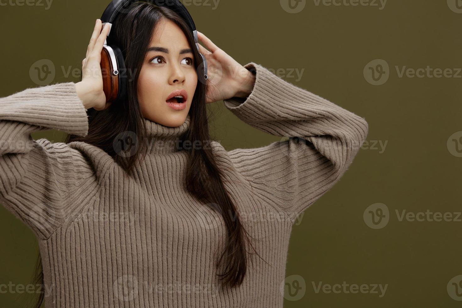 Frau im ein Sweatshirt Hören zu Musik- mit Kopfhörer Spaß Studio Modell- foto