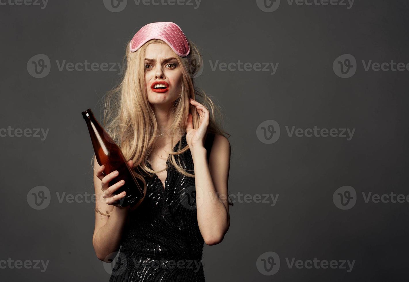 empört Frau mit ein Flasche von Bier und ein Rosa Maske auf das Kopf von ein blond Modell- foto