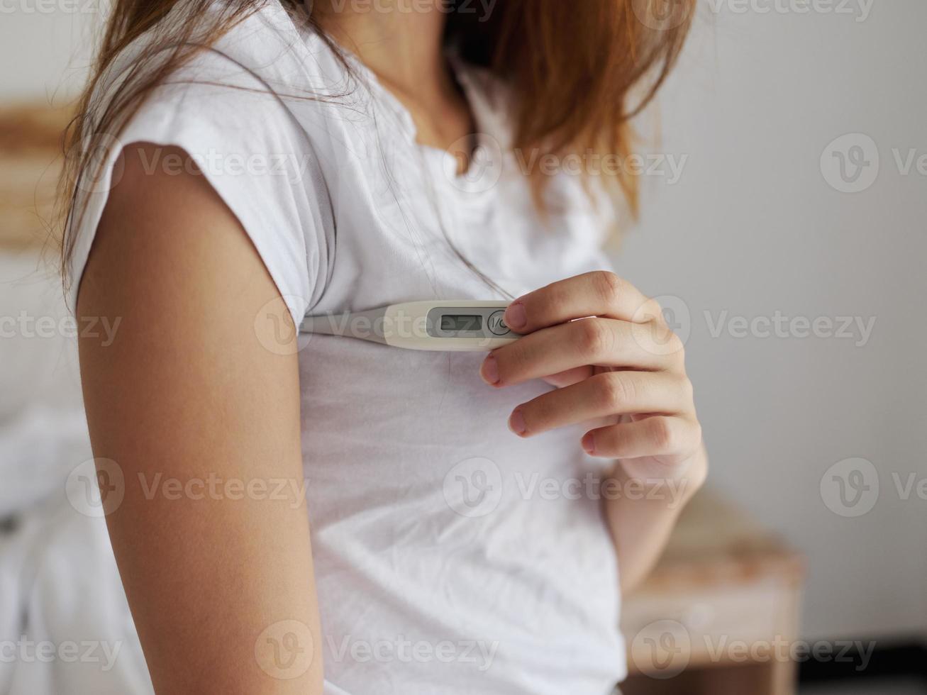 Frau mit Achsel Thermometer Überprüfung Temperatur abgeschnitten Aussicht foto