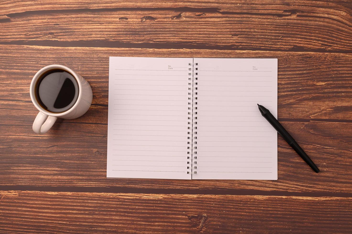 Kaffee und ein Notizbuch auf einem Schreibtisch foto
