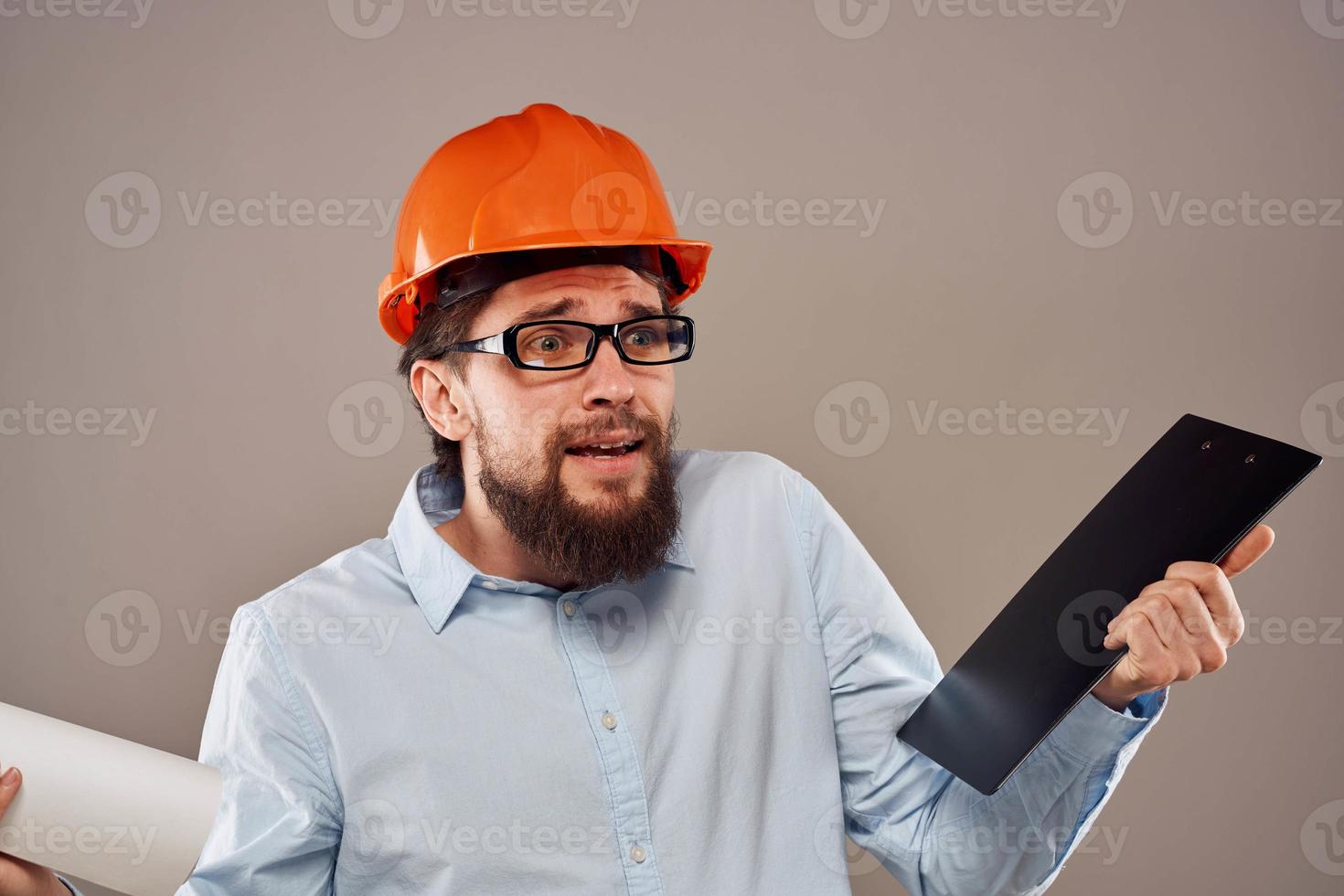 Mann im Konstruktion Uniform Orange Helm Zeichnungen Unterlagen Arbeit Dienstleistungen foto