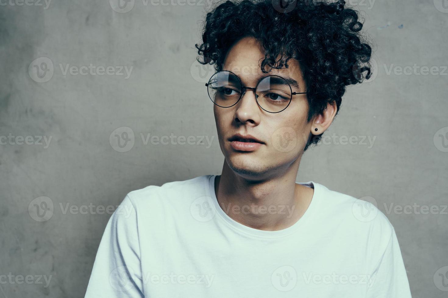 Mann mit lockig Haar tragen Brille Emotionen Weiß T-Shirt Studio foto