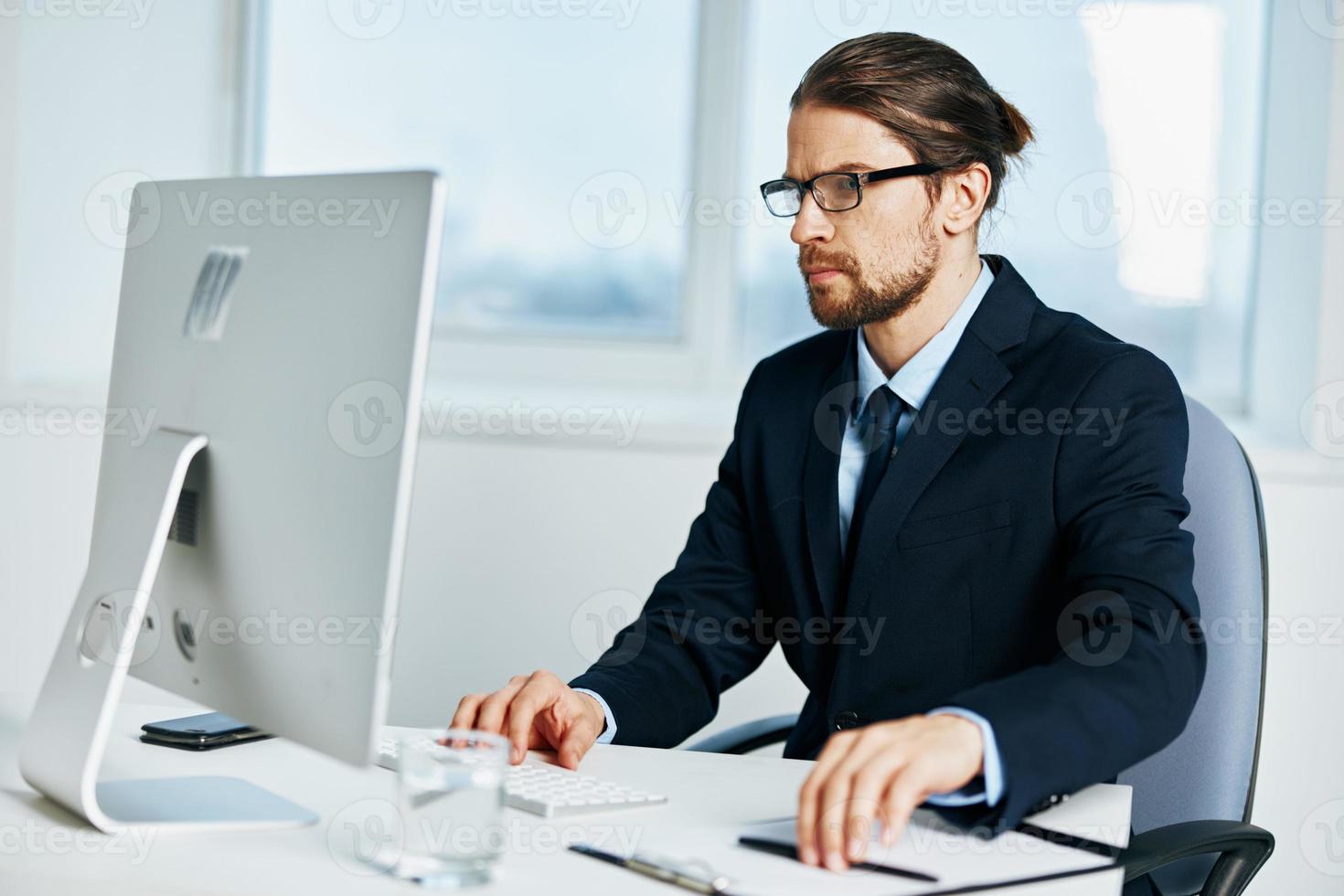 Geschäftsmann Sitzung beim ein Schreibtisch im Vorderseite von ein Computer Lebensstil foto