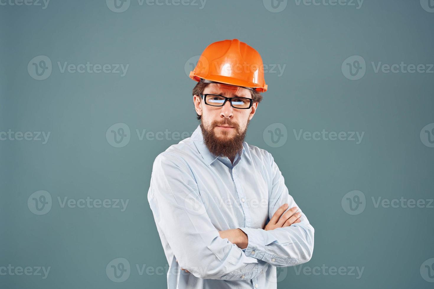 Mann im Orange schwer Hut Hemd abgeschnitten Aussicht Blau Hintergrund Konstruktion Arbeit foto