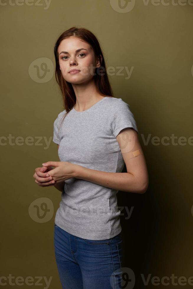 Frau im ein grau T-Shirt mit ein Gips auf ihr Arm covid Impfung Reisepass foto