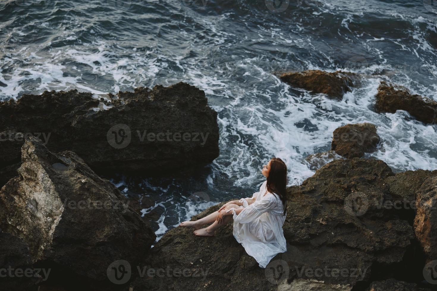 Frau mit nass Haar im Weiß Kleid Steine Natur Reise foto