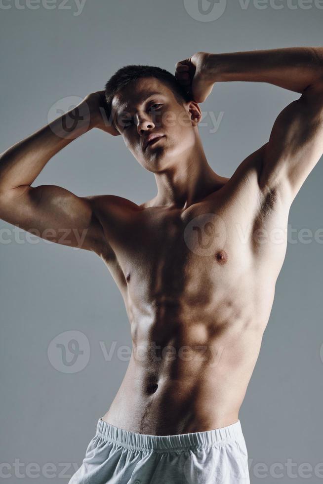 Mann mit ein gepumpt oben Torso hält seine Hände hinter seine Kopf Fitness trainieren Modell- foto