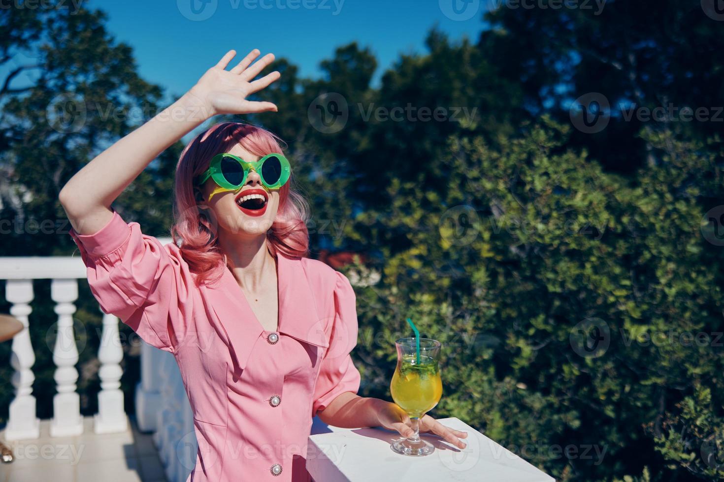 glamourös Frau im Grün Sonnenbrille mit Cocktail im Sommer- draußen Entspannung Konzept foto