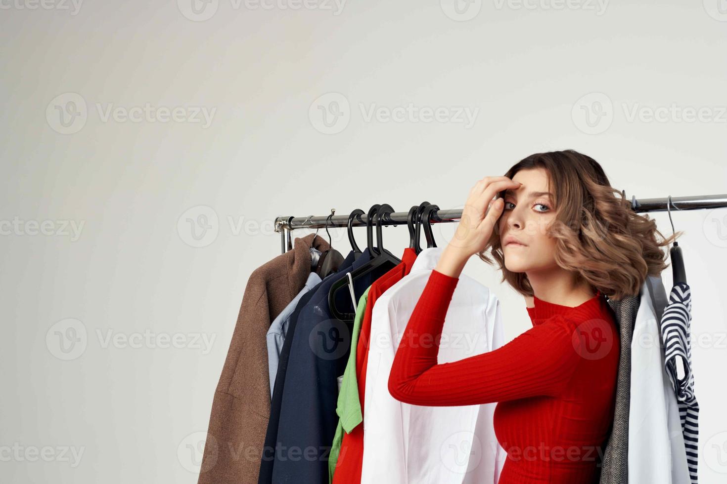 schön Frau versuchen auf Kleider Geschäft Shopaholic Licht Hintergrund foto