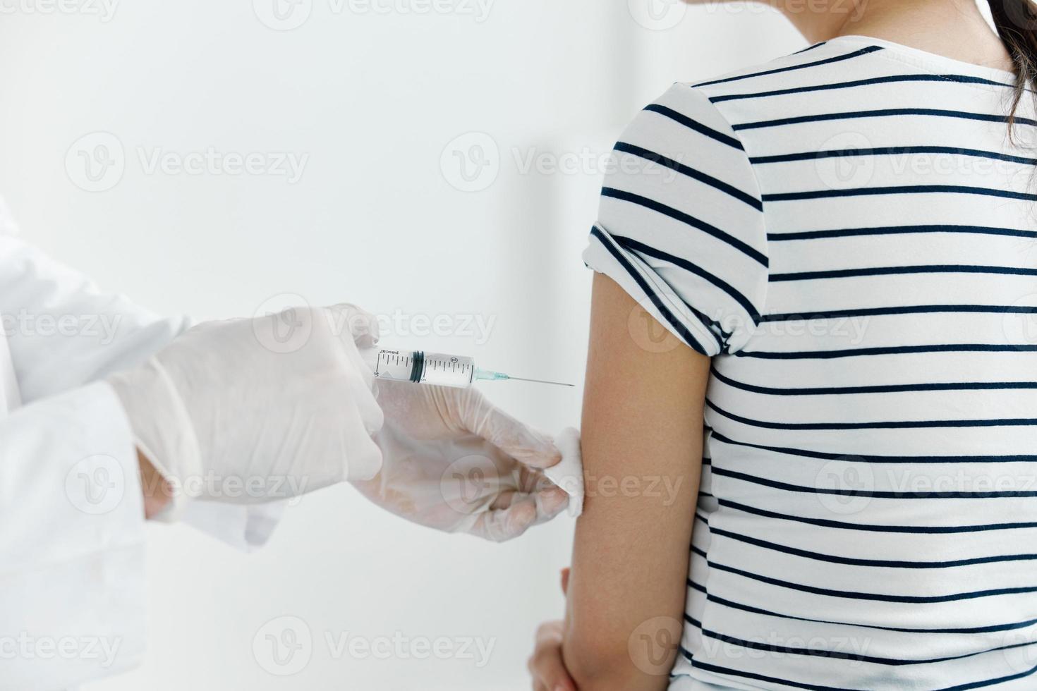 Arzt mit medizinisch Handschuhe spritzt das Impfstoff in das Patienten Hand Nahansicht foto