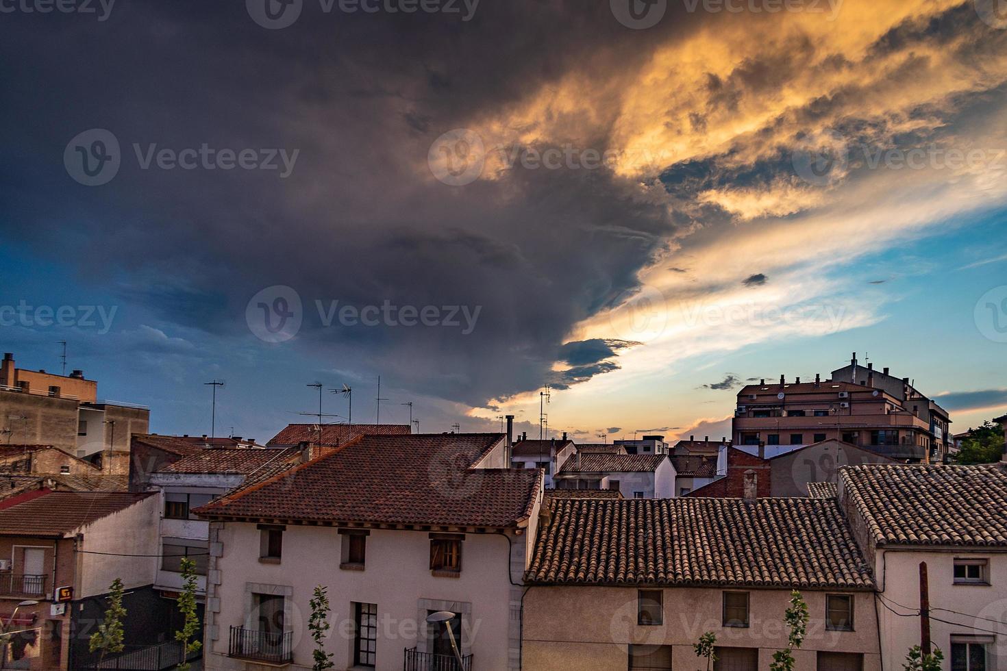 Abend Himmel mit dunkel Wolken Über ein klein Spanisch Stadt, Dorf foto