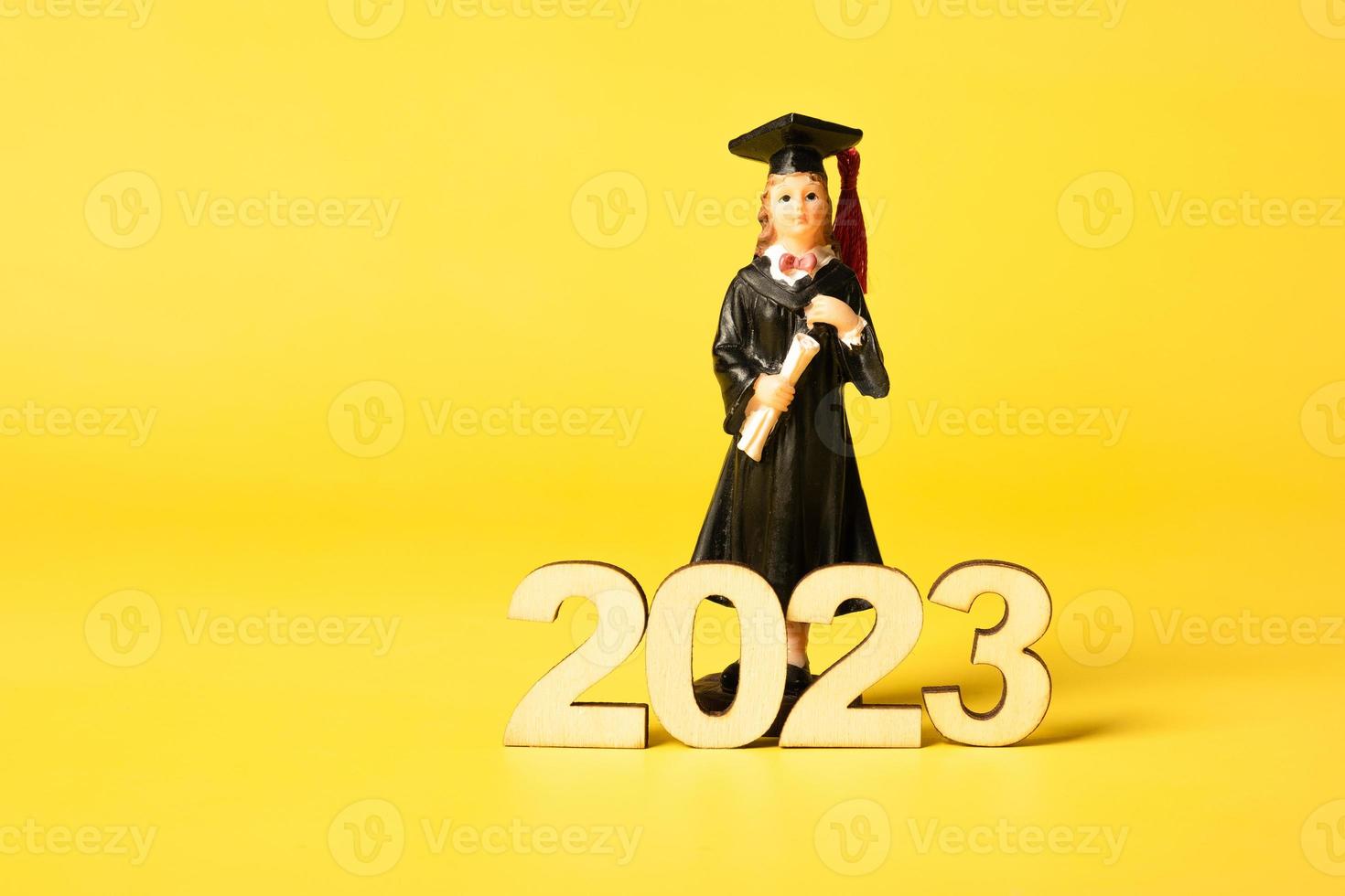 Klasse von 2023 Konzept. hölzern Nummer 2023 mit Absolvent Statuette auf Farbe Hintergrund foto