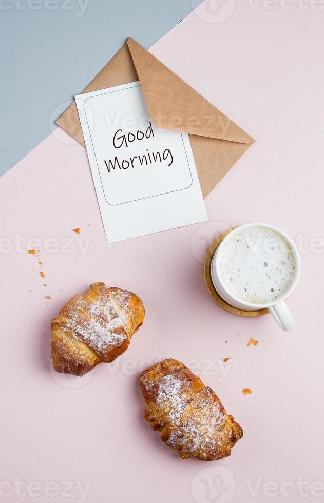 eben legen Komposition mit Tasse von Kaffee, Croissants und Postkarte mit Text gut Morgen foto
